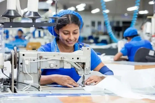 Sewing machine operator smiling while working on a garment